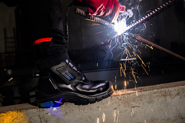 High-cut welding safety boot protecting a welder from sparks